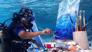 A scuba diver paints underwater.