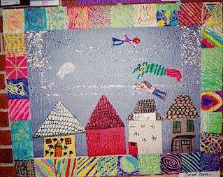 A story quilt craft depicting houses and people.