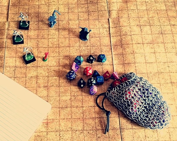 Miniatures and a bag of dice on a grid board
