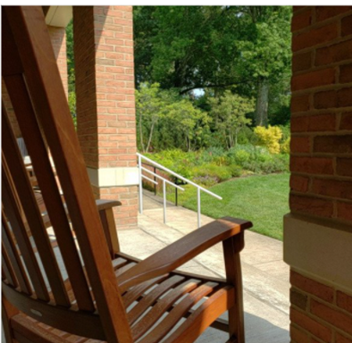 Rocking chair on porch with view of garden