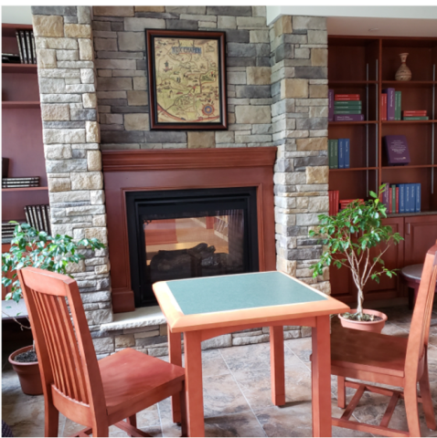 Small table and chairs in front of fireplace