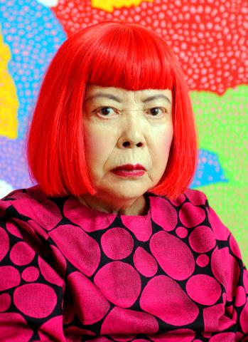 Photo of Yayoi Kusama with one of her paintings.