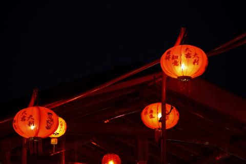 Paper lanterns glow on a dark night.