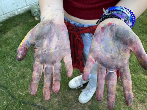 Hands covered in paint.