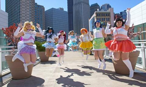 A photo of people cosplaying Aqours from Love Live Sunshine and jumping together.