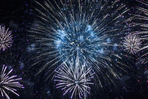 Blue and silver fireworks light up a night sky