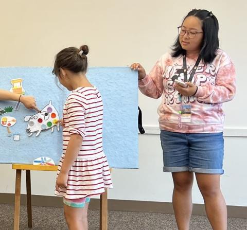 Miss CC helps kids add colorful spots to a white dog.