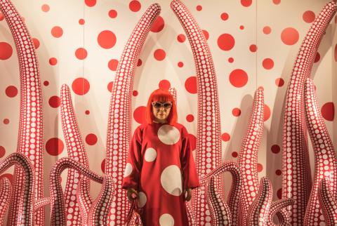 Photo of Yayoi Kusama with one of her art installations