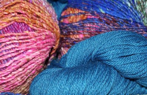 A close up photo of multi-colored skeins of yarn.