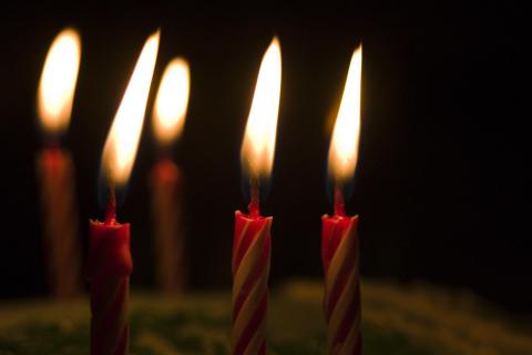 Photo of lit candles on a birthday cake