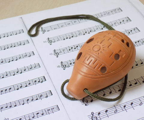 A photo of an ocarina on sheet music.