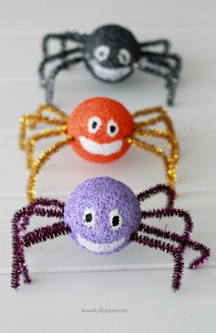 There are there crafted spiders in a line. They are made from styrofoam balls and pipe cleaners with happy faces painted on them.