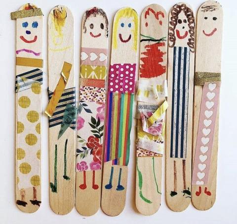 Several popsicle sticks are shown with family members drawn on each one.