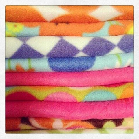 Brightly-colored, polar fleece fabric in a stack.