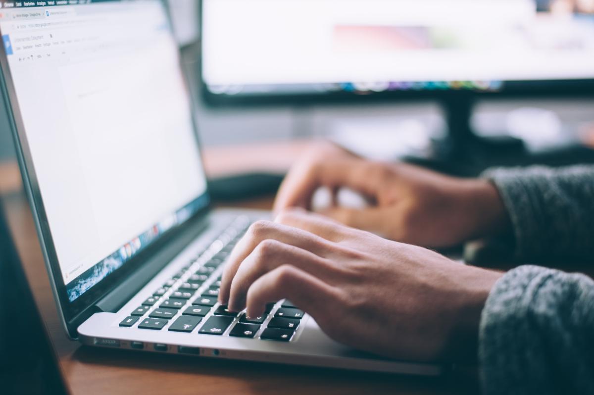 Hands typing on laptop