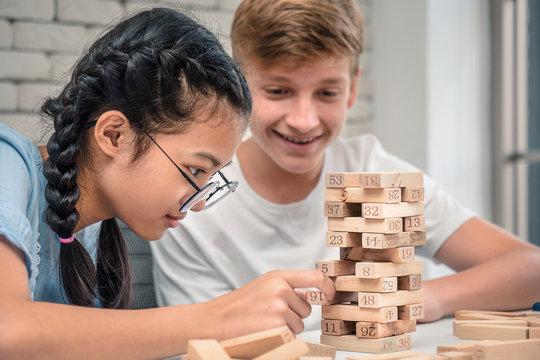 Multicultural teens play Jenga.