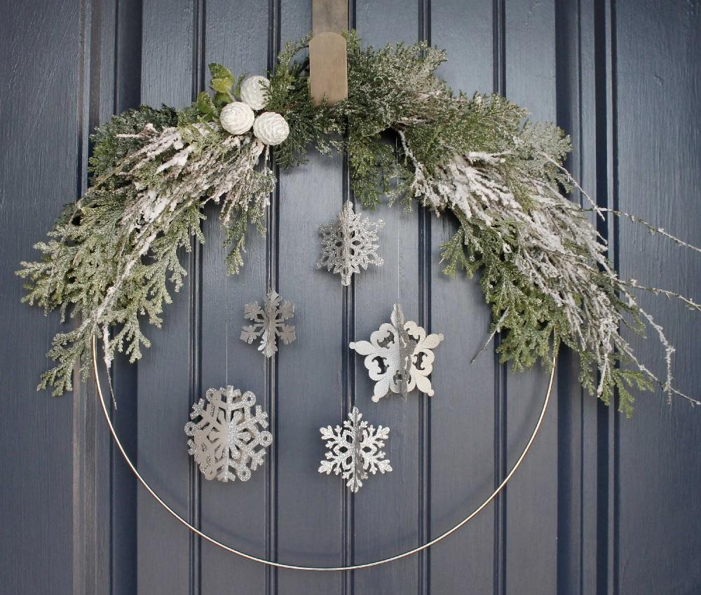 A wreath with pine boughs and snowflakes affixed.