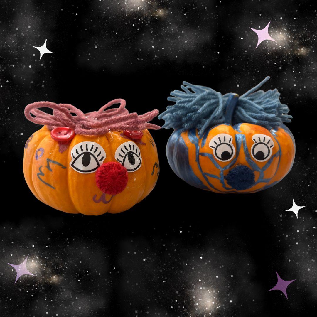 Two decorated mini-pumpkins on a black star background