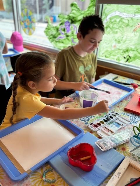 Photo of 2 kids working on art projects at the library