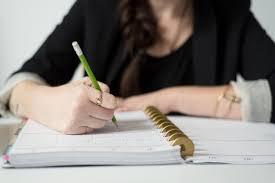 Photo of person writing in notebook