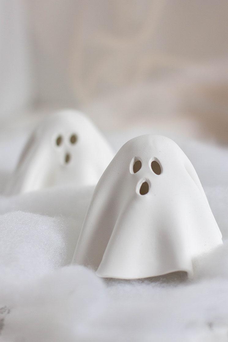 A photograph of two small, white ghost sculptures.