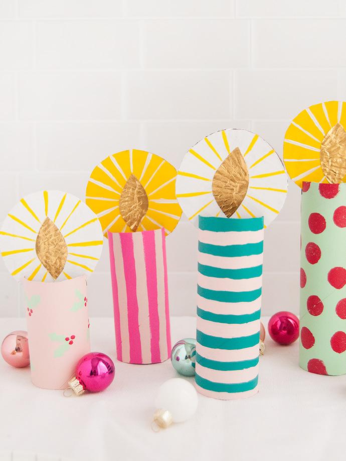 A photo of four colorful, cardboard candles created out of TP rolls.