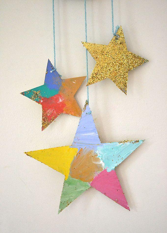 Three hanging, cardboard stars have been painted and glitter-covered.