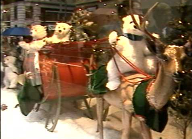 Photo of holiday window display featuring Santa's sleigh with bears and reindeer